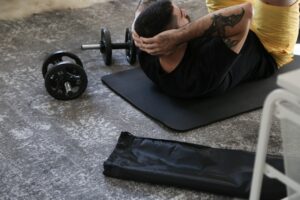 Beginner exercising in a bright living room using a chair for supported squats.