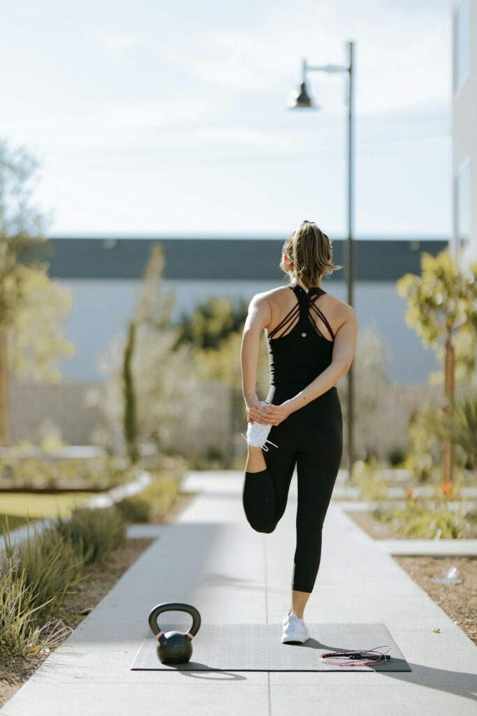 A person alternates between brisk walking and dumbbell exercises in a bright home workout space.