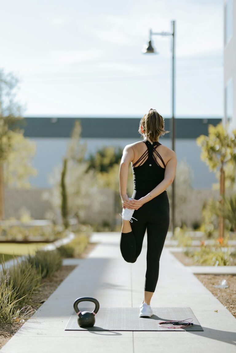 A person alternates between brisk walking and dumbbell exercises in a bright home workout space.